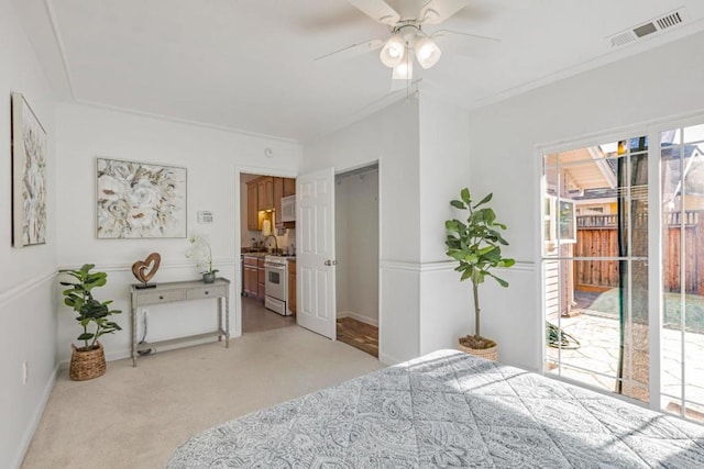 carpeted bedroom with ornamental molding, access to exterior, and ceiling fan