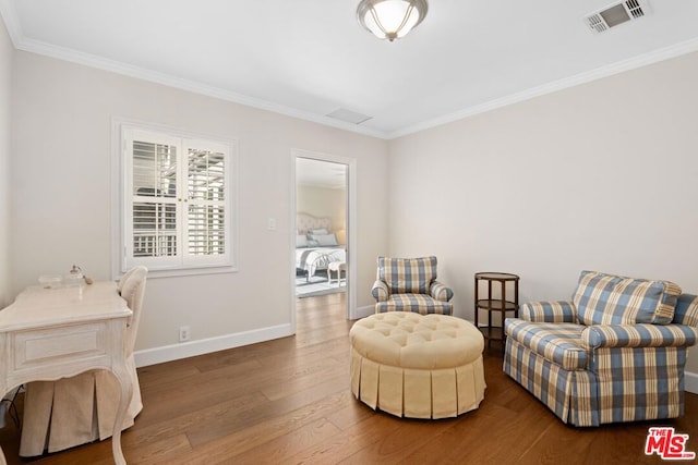 sitting room featuring hardwood / wood-style flooring and crown molding