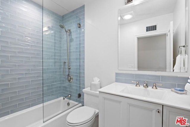 full bathroom featuring tasteful backsplash, vanity, toilet, and tiled shower / bath combo