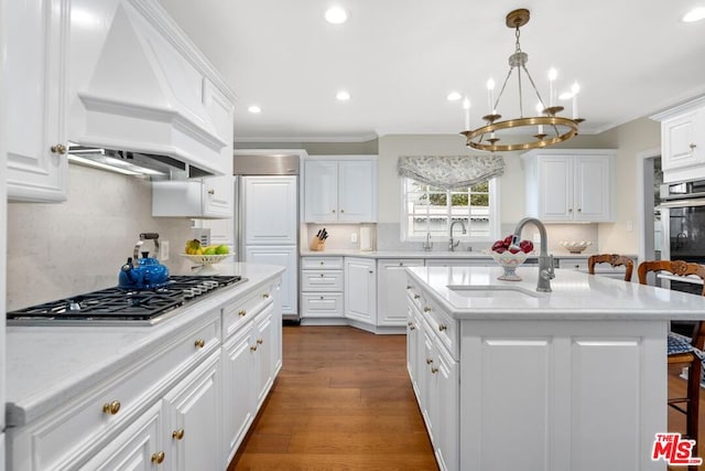 kitchen with white cabinetry, sink, a breakfast bar area, a center island, and custom range hood