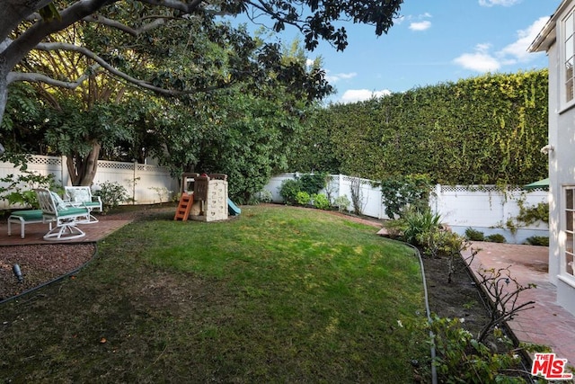 view of yard with a playground and a patio area