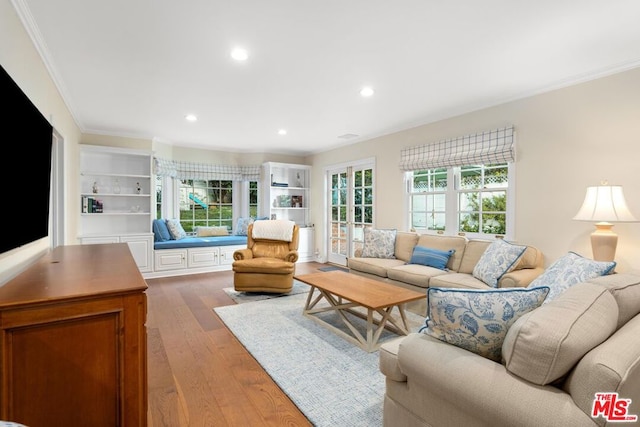 living room featuring wood-type flooring, ornamental molding, and french doors