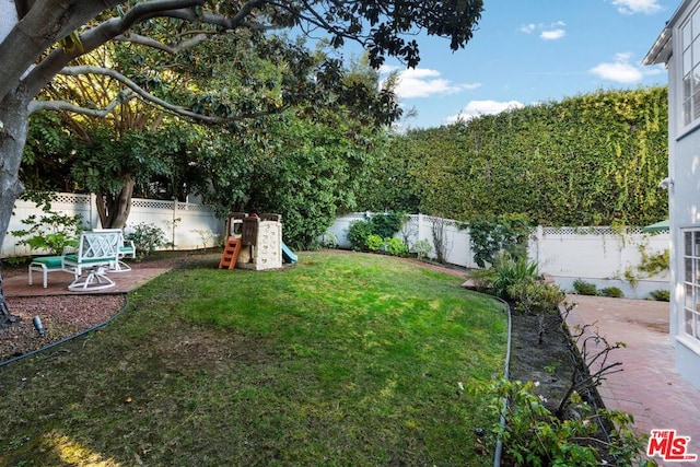 view of yard featuring a playground and a patio area