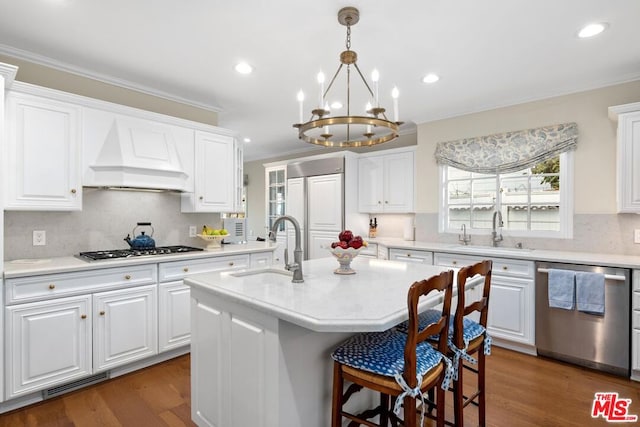 kitchen featuring white cabinetry, appliances with stainless steel finishes, sink, and a kitchen island with sink