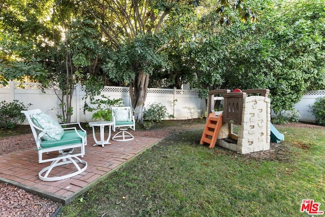 view of yard with a playground and a patio area