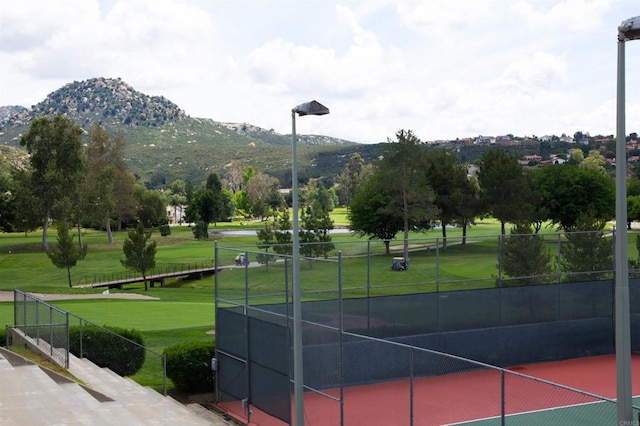 view of community with a mountain view and tennis court