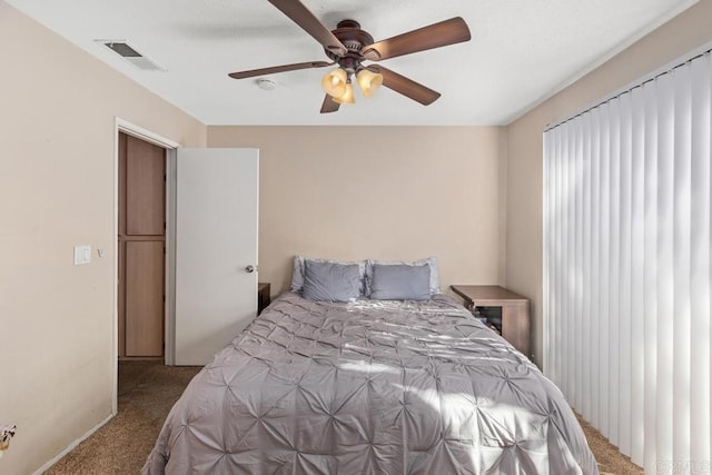 bedroom featuring a ceiling fan, visible vents, and carpet flooring