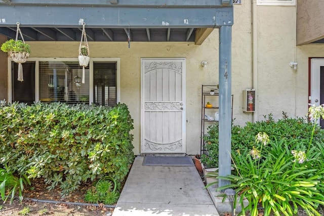 entrance to property featuring stucco siding