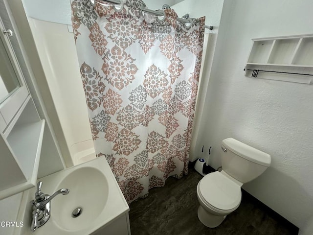 bathroom featuring a shower with shower curtain, vanity, and toilet