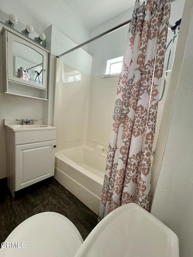 bathroom featuring toilet, shower / tub combo, and vanity