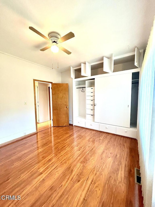 unfurnished bedroom featuring visible vents, ceiling fan, baseboards, and wood finished floors