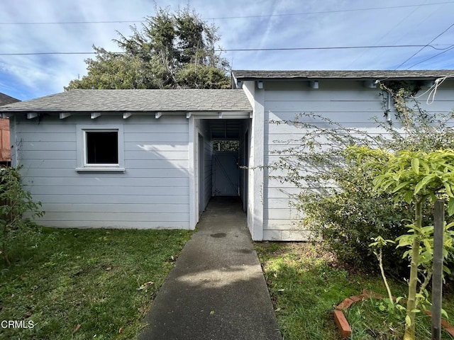 view of exterior entry with a shingled roof