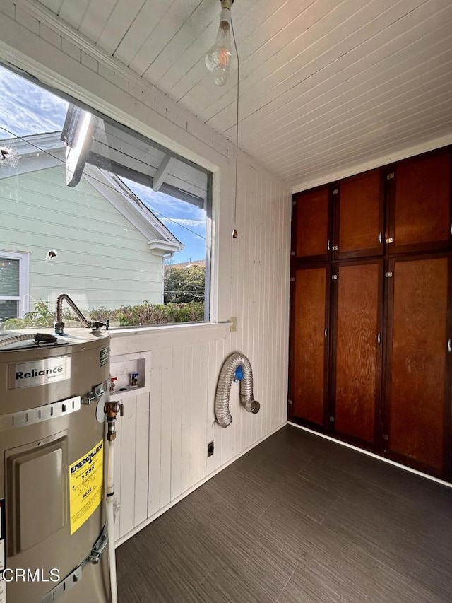 clothes washing area featuring cabinet space and water heater