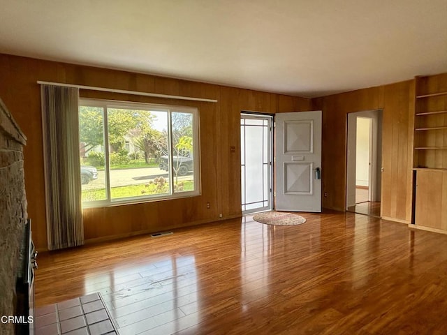 interior space featuring wood walls, wood finished floors, and visible vents