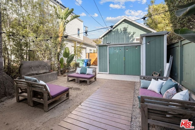 wooden terrace with a storage shed and outdoor lounge area