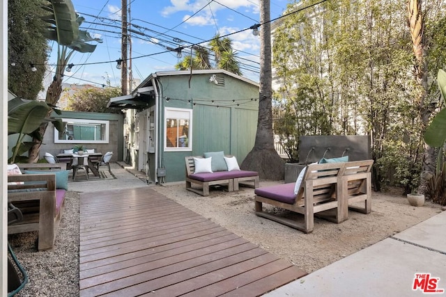 wooden deck featuring an outbuilding and a patio area