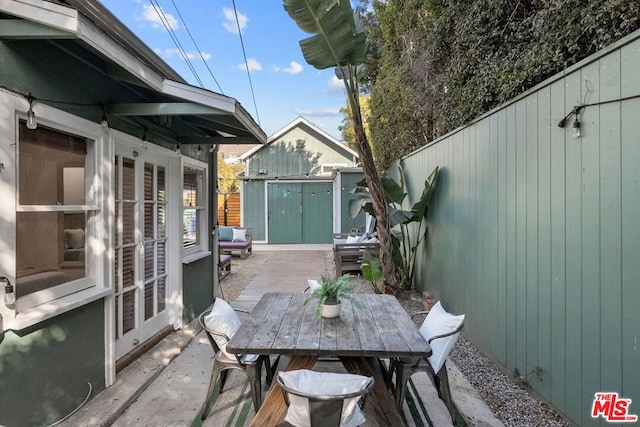 view of patio / terrace with french doors and a shed