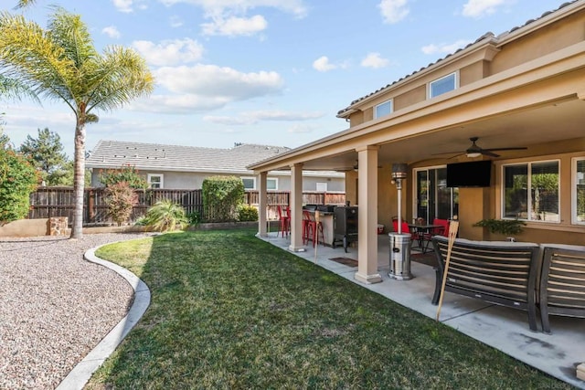 view of yard featuring ceiling fan, exterior bar, and a patio