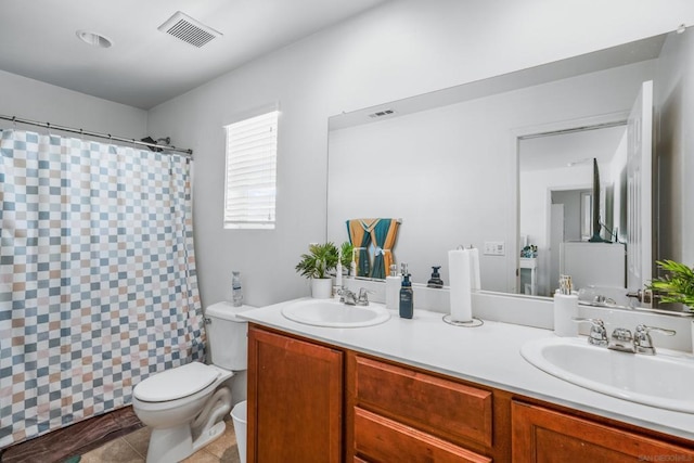 bathroom with a shower with curtain, tile patterned floors, vanity, and toilet