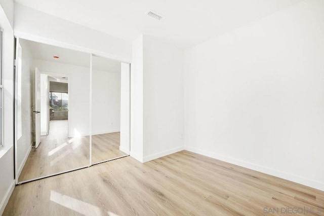 unfurnished bedroom with light hardwood / wood-style floors and a closet