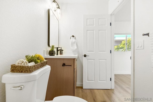 bathroom with vanity, wood-type flooring, and toilet