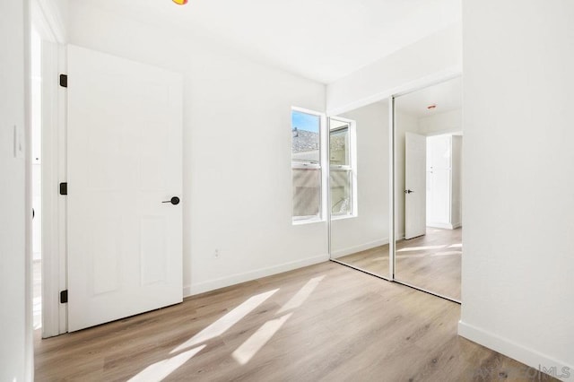 unfurnished bedroom featuring light wood-type flooring and a closet