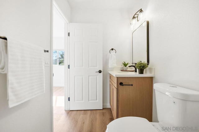 bathroom with vanity, hardwood / wood-style floors, and toilet