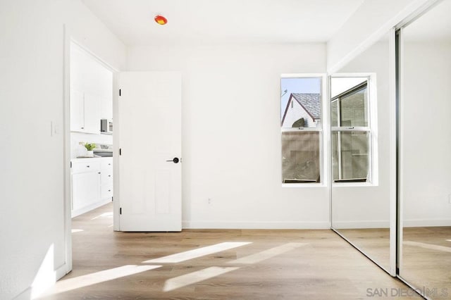 unfurnished bedroom with a closet and light hardwood / wood-style flooring