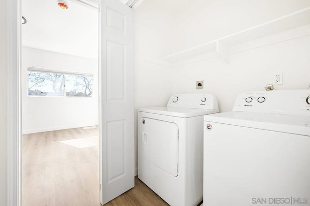 clothes washing area featuring hardwood / wood-style floors and washer and clothes dryer