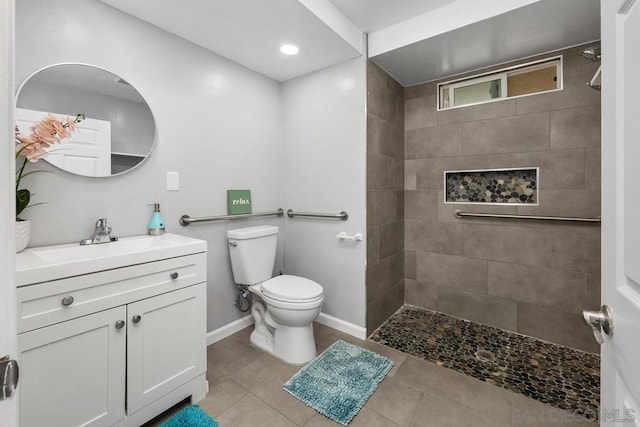 bathroom with vanity, toilet, and a tile shower