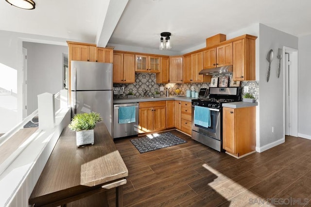 kitchen featuring tasteful backsplash, dark hardwood / wood-style flooring, appliances with stainless steel finishes, and beam ceiling