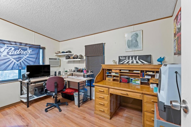 office space featuring ornamental molding, a wall mounted AC, light hardwood / wood-style floors, and a textured ceiling