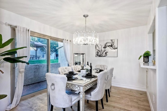 dining space with light hardwood / wood-style flooring and a chandelier