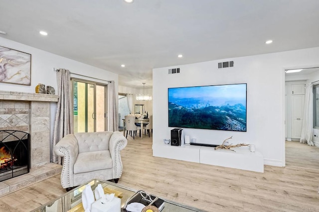 living area with an inviting chandelier, recessed lighting, visible vents, and light wood-type flooring