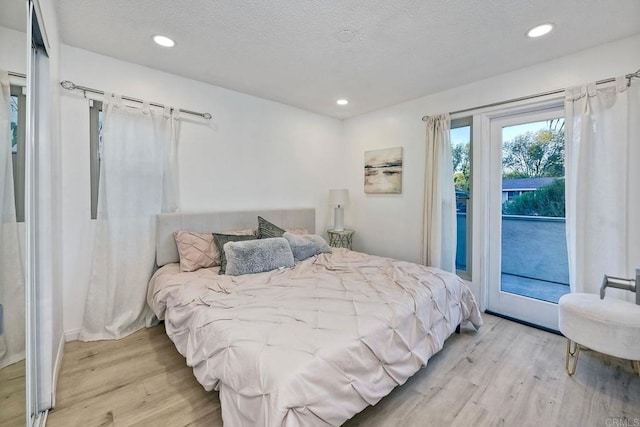 bedroom featuring recessed lighting, a textured ceiling, wood finished floors, and access to outside