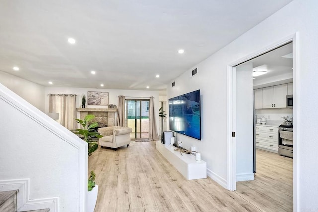 living area with light wood-style flooring, recessed lighting, and visible vents
