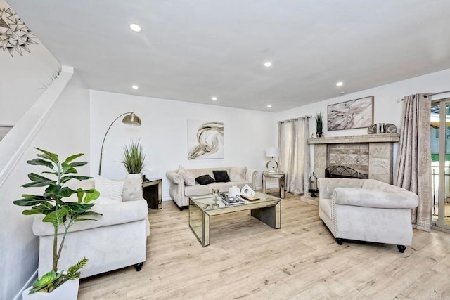 living room featuring recessed lighting, a fireplace, and wood finished floors