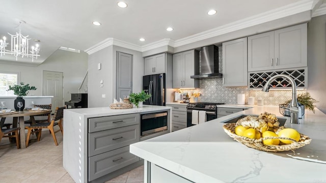 kitchen with appliances with stainless steel finishes, tasteful backsplash, sink, gray cabinetry, and wall chimney exhaust hood