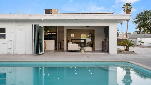 view of pool with central AC unit, an outdoor structure, and a patio