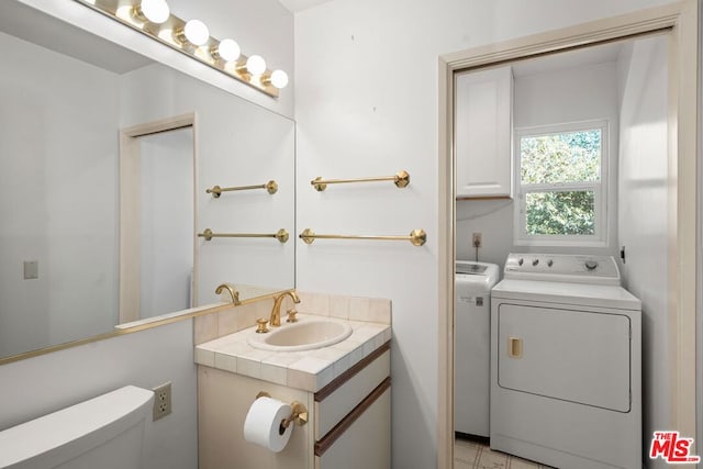 bathroom featuring vanity, separate washer and dryer, and toilet