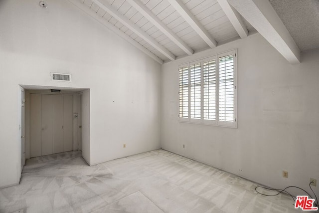 unfurnished bedroom with high vaulted ceiling, beam ceiling, and light colored carpet