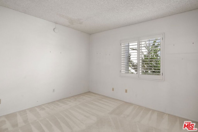 carpeted spare room featuring a textured ceiling