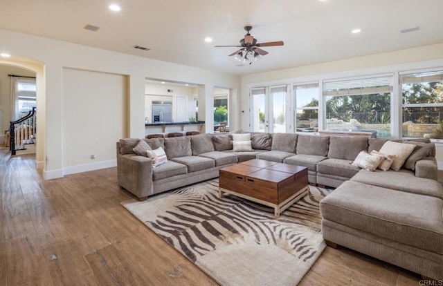 living room with ceiling fan and light hardwood / wood-style flooring