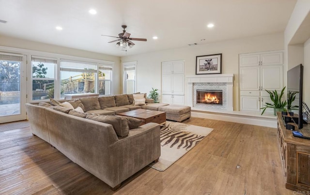 living room with ceiling fan and light hardwood / wood-style floors