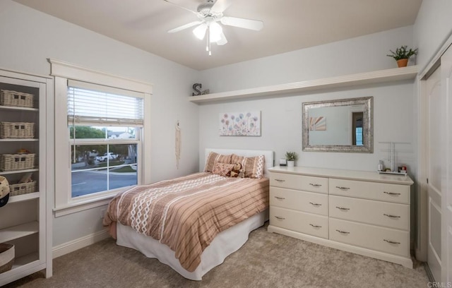 bedroom featuring light carpet, ceiling fan, and a closet