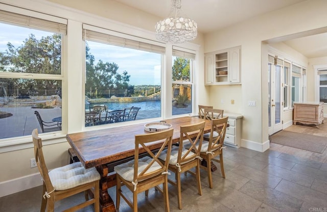 dining room featuring a notable chandelier and a water view