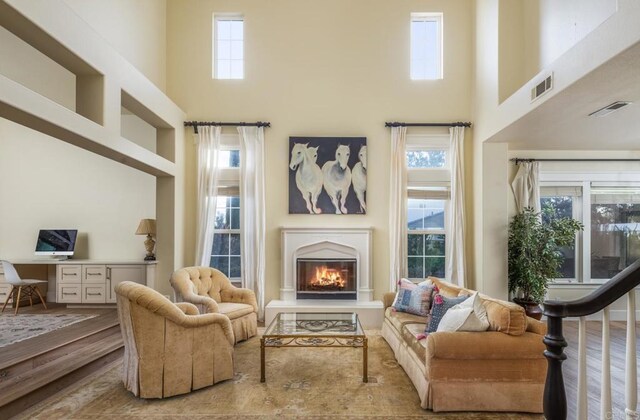 living area featuring built in desk, plenty of natural light, and a high ceiling