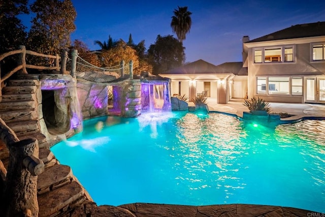 view of swimming pool with pool water feature and a patio area