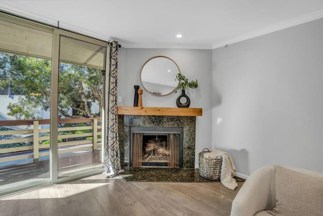 living room featuring crown molding, hardwood / wood-style flooring, and a premium fireplace