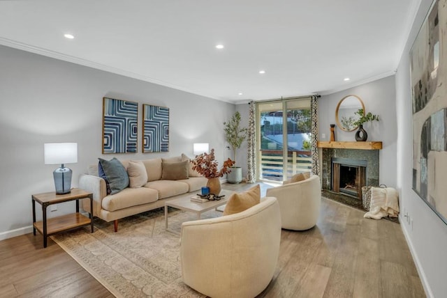 living room with crown molding, a fireplace, and wood-type flooring